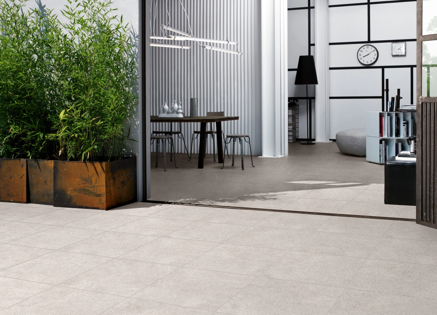 Płytki gresowe Marazzi Work efekt beton w eleganckim salonie z dużymi przeszkleniami