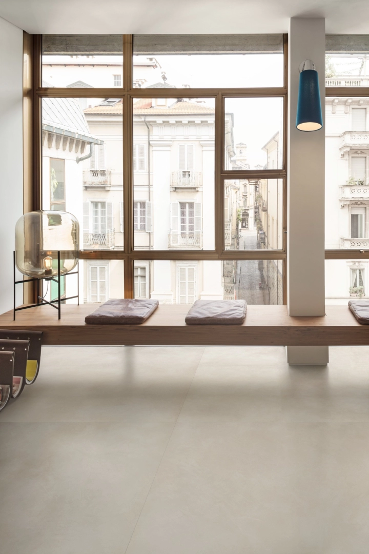 Płytki gresowe Marazzi Grande Resin Look efekt żywica w eleganckim salonie z dużymi przeszkleniami