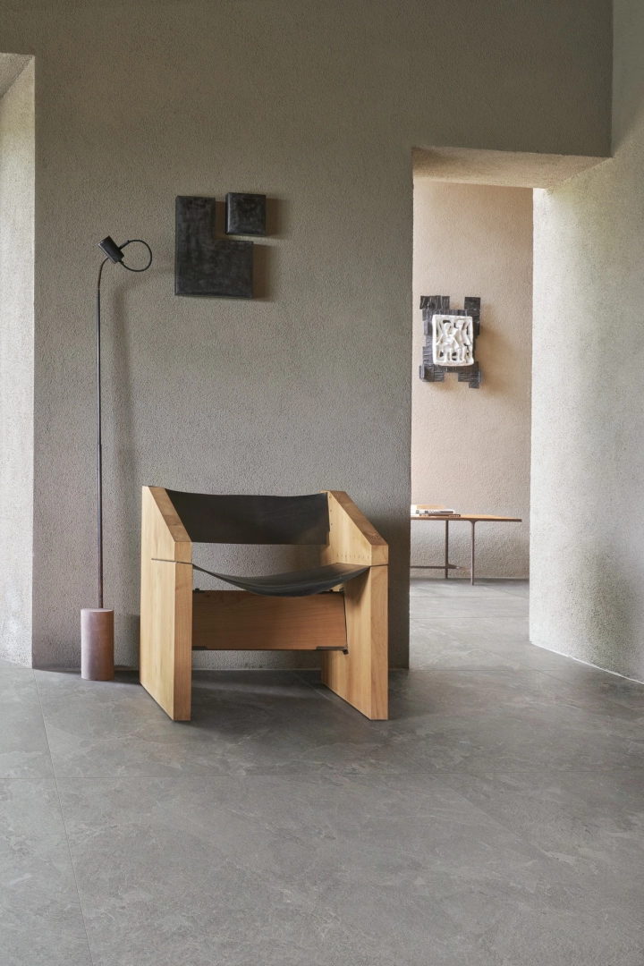 Płytki Marazzi Mystone Pietra Ligure imitujące kamień naturalny w salonie z dużym przeszkleniem