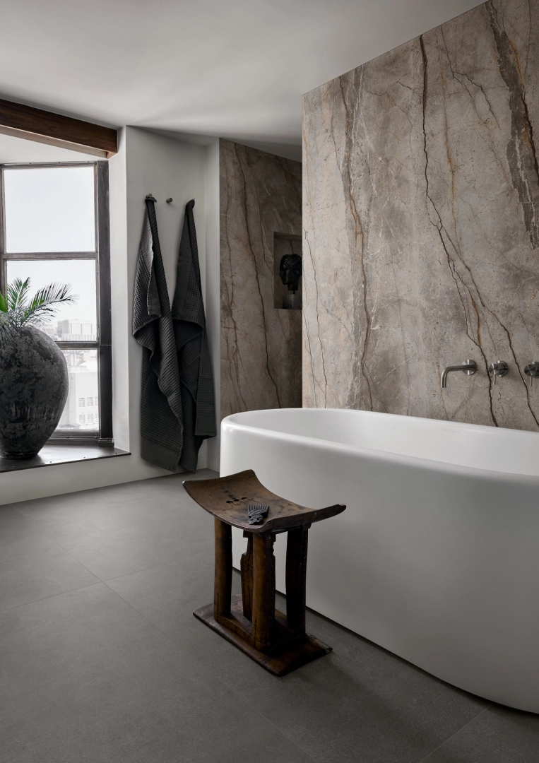 Płytki gresowe Marazzi Grande Stone Look efekt kamień naturalny w eleganckim salonie z dużymi przeszkleniami