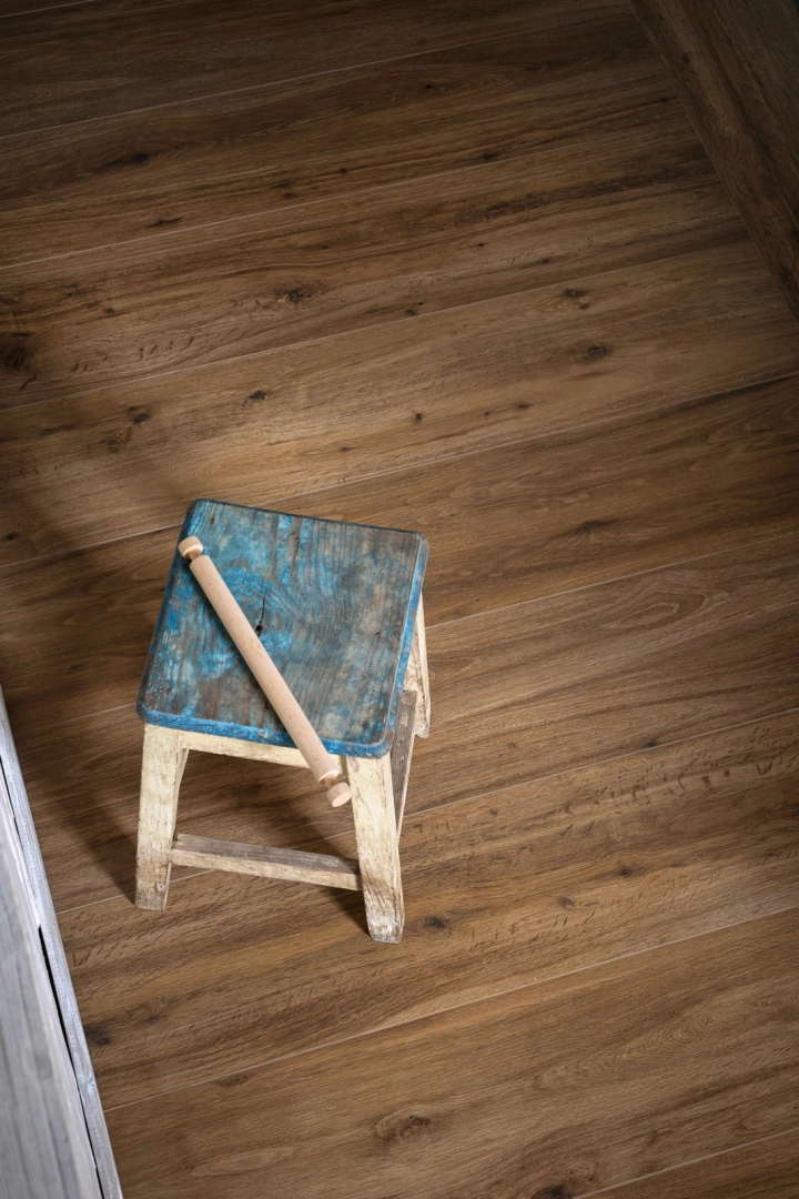 Wielkoformatowy gres Marazzi Treverktrend efekt drewno w salonie z kominkiem