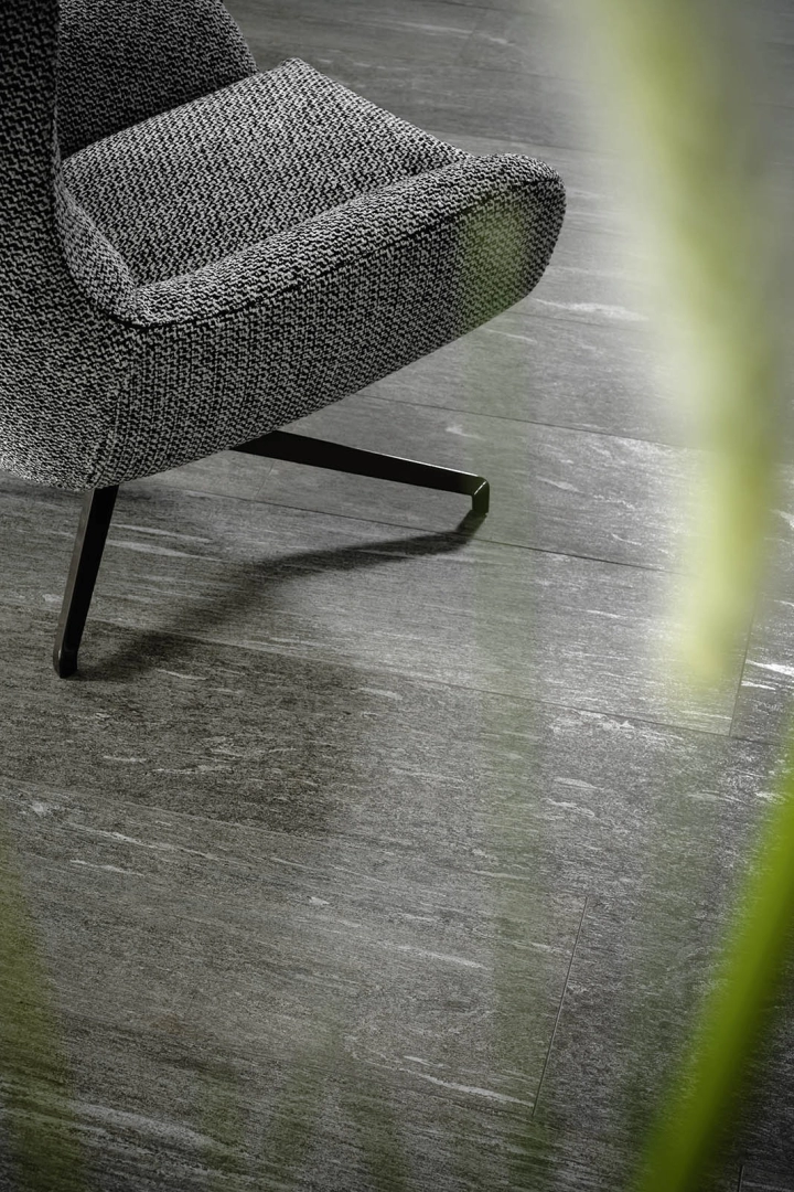 Wielkoformatowy gres Marazzi Mystone Pietra DI Vals efekt kamień naturalny w salonie z kominkiem