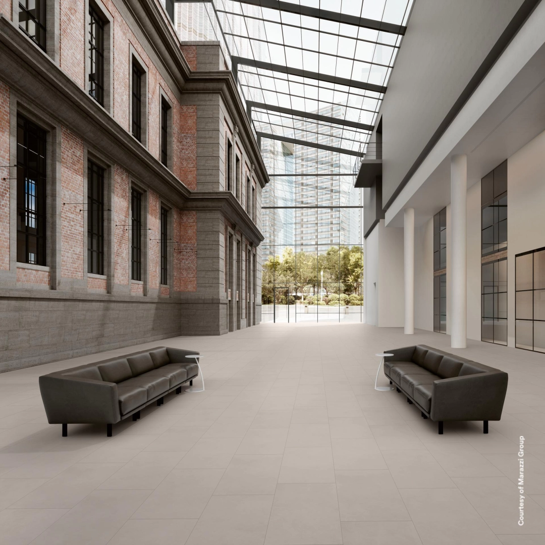 Płytki gresowe Marazzi Sistems efekt kamień naturalny w eleganckim salonie z dużymi przeszkleniami