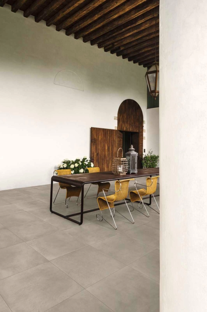 Płytki gresowe Marazzi Powder efekt beton w eleganckim salonie z dużymi przeszkleniami