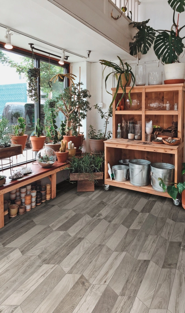 Płytki gresowe Marazzi Treverksoul efekt drewno w eleganckim salonie z dużymi przeszkleniami