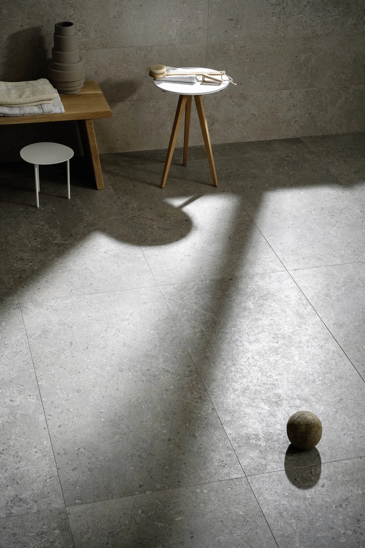 Płytki gresowe Marazzi Mystone Gris Fleury efekt kamień naturalny w eleganckim salonie z dużymi przeszkleniami