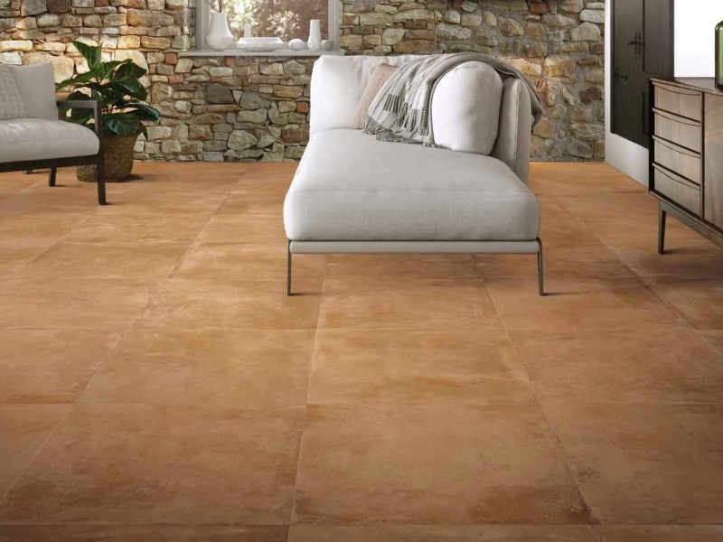 Wielkoformatowy gres Marazzi Cotti D'italia efekt terakota w salonie z kominkiem