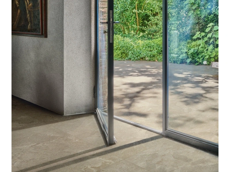 Wielkoformatowy gres Marazzi Mystone Pietra Ligure efekt kamień naturalny w salonie z kominkiem