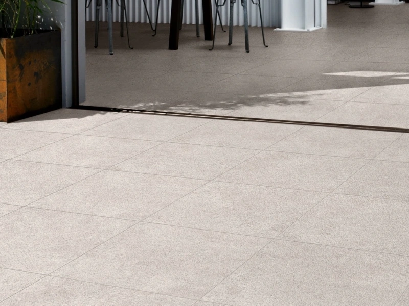 Płytki gresowe Marazzi Work efekt beton w eleganckim salonie z dużymi przeszkleniami
