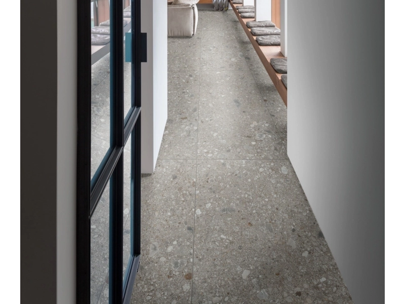 Wielkoformatowy gres Marazzi Mystone Ceppo DI Gre efekt terrazzo w salonie z kominkiem