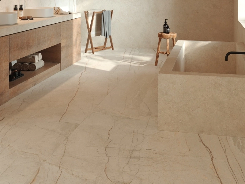 Płytki Marazzi Grande Stone Look imitujące kamień naturalny w salonie z dużym przeszkleniem