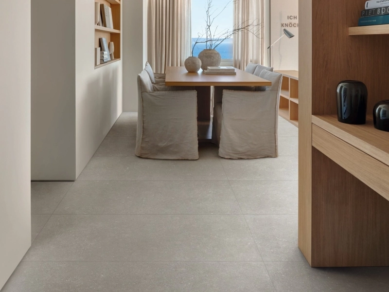 Płytki Marazzi Mystone Berici imitujące kamień naturalny w salonie z dużym przeszkleniem