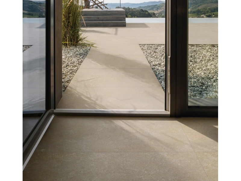 Wielkoformatowy gres Marazzi Mystone Berici efekt kamień naturalny w salonie z widokiem na ogród