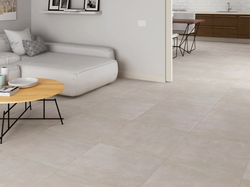 Płytki gresowe Marazzi Dust efekt beton w eleganckim salonie z dużymi przeszkleniami