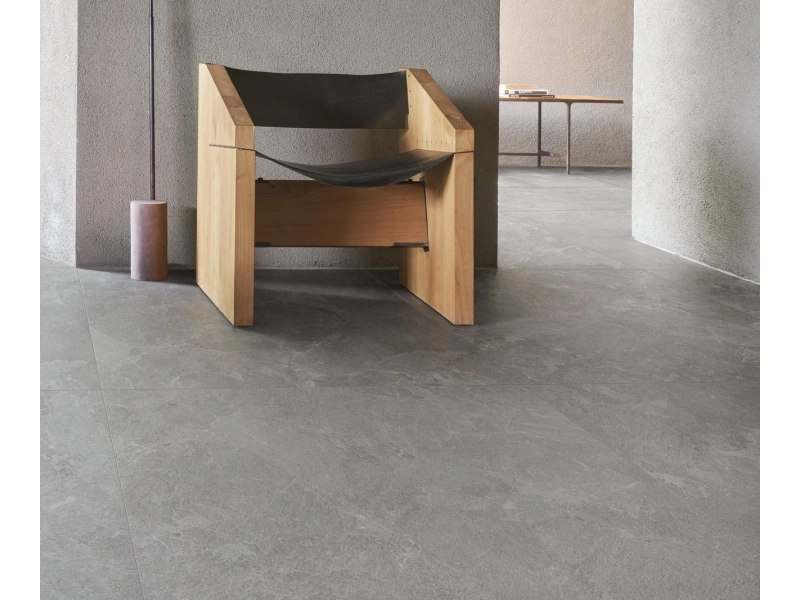Płytki Marazzi Mystone Pietra Ligure imitujące kamień naturalny w salonie z dużym przeszkleniem