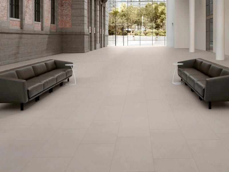Płytki gresowe Marazzi Sistems efekt kamień naturalny w eleganckim salonie z dużymi przeszkleniami