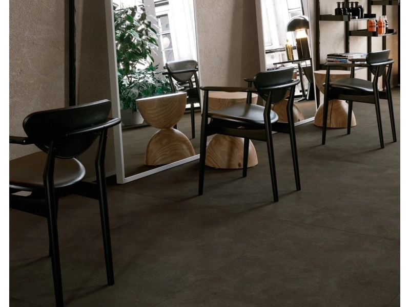 Płytki Marazzi Terratech imitujące beton w salonie z dużym przeszkleniem