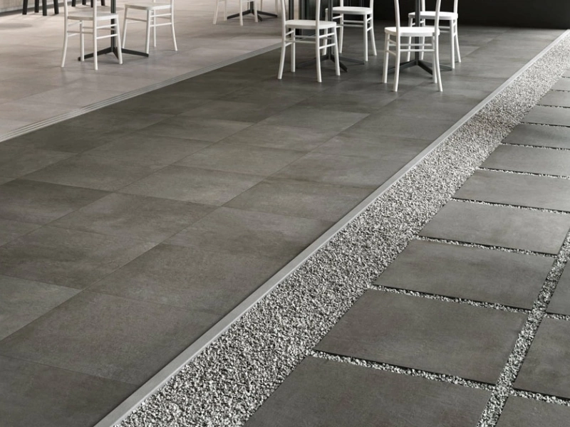 Wielkoformatowy gres Marazzi Plaster efekt beton w salonie z kominkiem