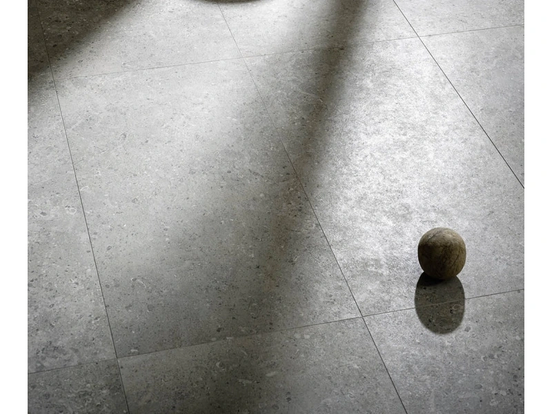 Płytki gresowe Marazzi Mystone Gris Fleury efekt kamień naturalny w eleganckim salonie z dużymi przeszkleniami
